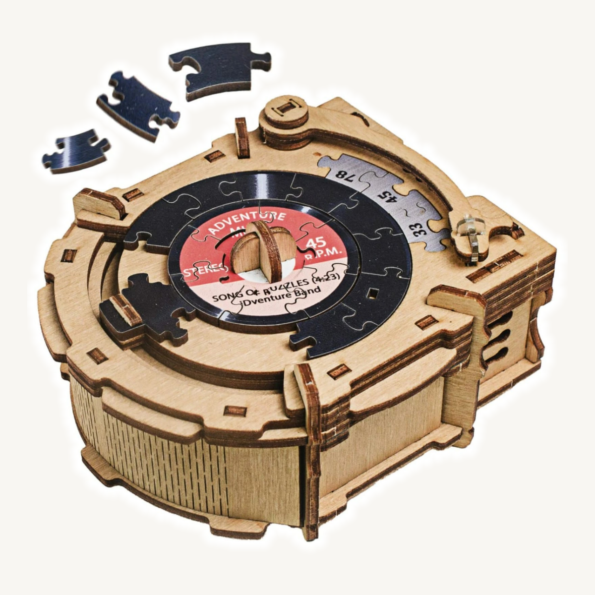 iDventure Record Player wooden jigsaw puzzle box with three detached pieces on a light neutral background.